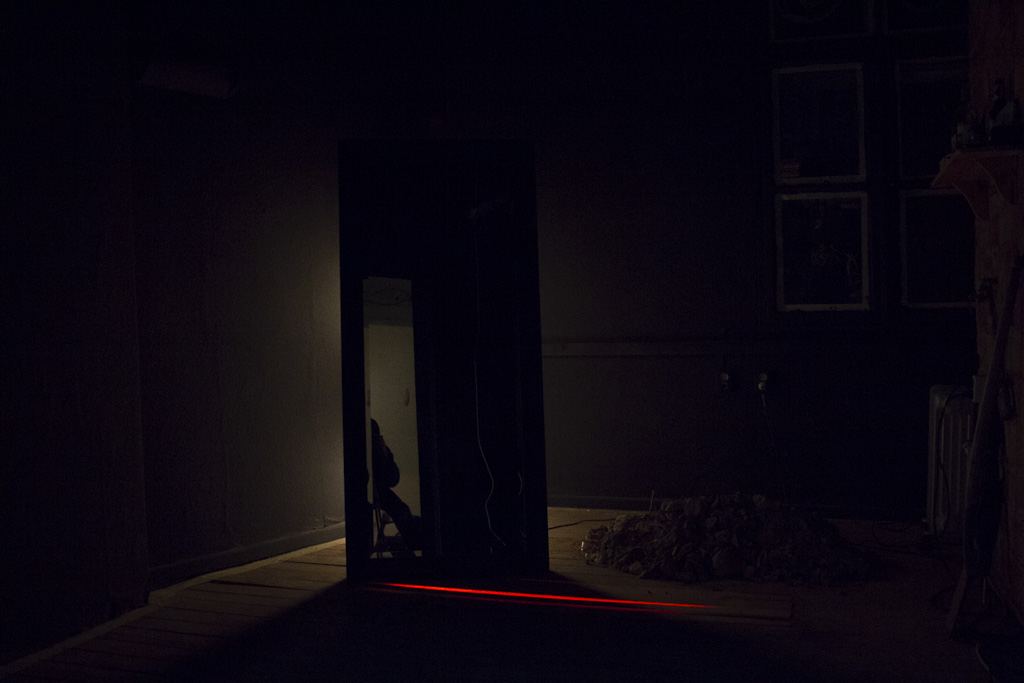 Archaeology — dark room view with neon glow under door