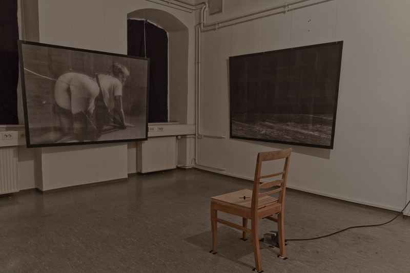 Schwarz Zimmer — installation view, chair facing screens