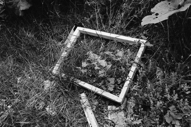Witness — discarded window frame in grass